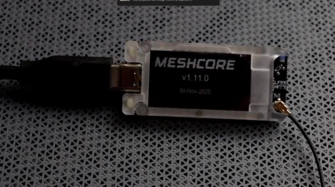 Een LoRa bordje met het woord ‘Meshcore’ op het kleine schermpje.